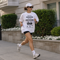Remera Oversize Run With Passion durante carrera, vista frontal con biker negro