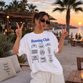 Remera Oversize Running Club blanca, vista frontal en ambiente costero al atardecer